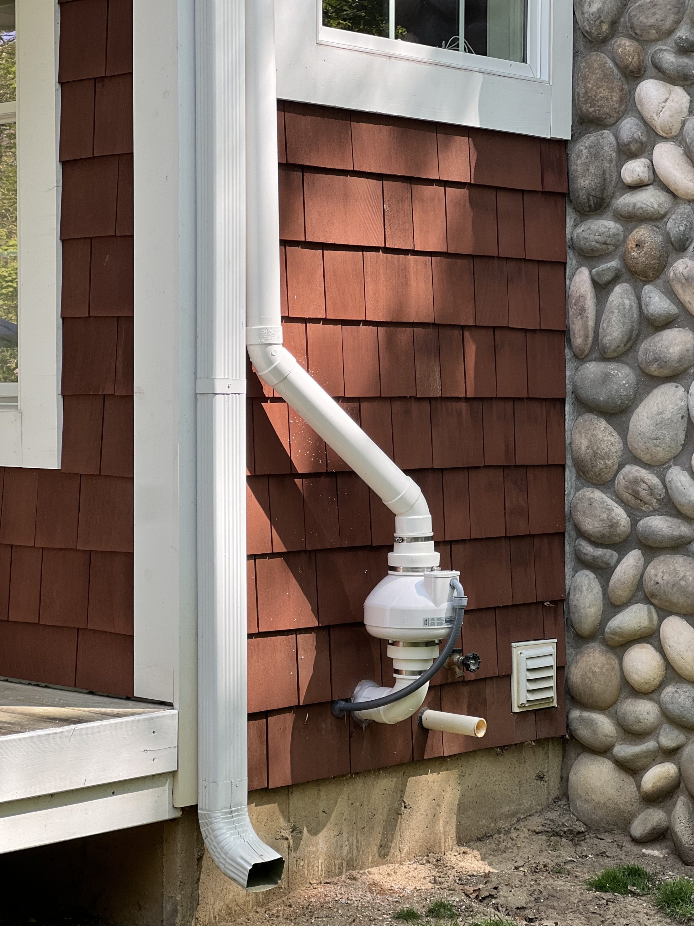 Radon mitigation system installed on house exterior in Detroit