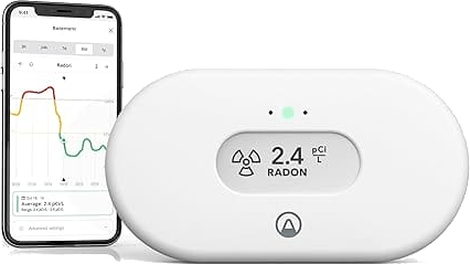 Radon monitor displaying 2.4 pCi/L next to smartphone app interface for Detroit monitoring